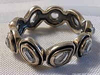 Close-up of sterling silver ring showing the oxidized inner band and bezel settings with clear faceted stones.