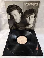 Vinyl LP record on display alongside front cover sleeve featuring black and white portrait of band members