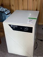 White Mastercraft D20 dehumidifier showing full unit with vented front panel and top control area.