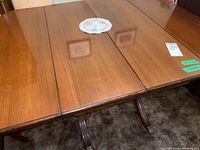 Front view of the wood double pedestal dining table with leaves extended showing rectangular top and pedestals.