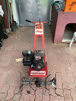 Front view of red Atlas power tiller showing handlebar, engine and tiller blades