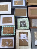 Overview photo showing eleven assorted picture frames laid out on a black surface, displaying various sizes, colors, and styles.