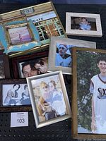 Nine photo frames containing color and black and white photographs, various sizes and styles, arranged together