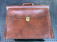 Full front view of the brown leather Texier briefcase showing the flap and handle.