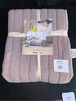 Packaged Ellen Degeneres brand full/queen quilt, folded and tied with light cream straps, showing front label with product image and branding.