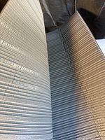 Close-up photo of beige ribbed textured surface of the Notrax anti fatigue mat, showing ribs and folds.