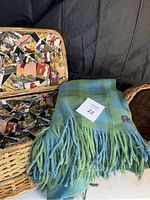 Image of the picnic basket lined with colorful vintage print fabric and the Pendleton blanket draped over the basket edge.