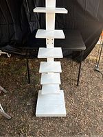 Front view of the white standing bookshelf showing the spine design and staggered shelves.