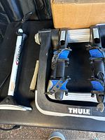 Photo showing Thule bike rack and Serfas bike pump side by side on a black surface.