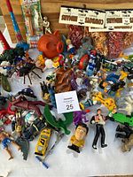 Top down view showing a mixture of various toy figurines, vehicles, and collectibles including Pez dispensers and animals.