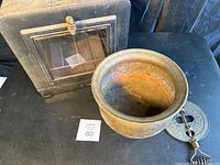 Brass pot inside the stove showing the crack and wear