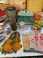 Overview of vintage tins, jars, Goldey hair rinse display box, popcorn holders, and other assorted vintage packaging items.