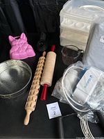 Full display of items including water purifier in bag, rolling pins, pink rabbit mold, measuring cup, wire whisk, and cupcake holder