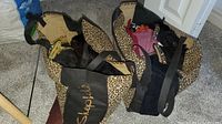 Two leopard-print tote bags filled with gloves on carpet