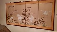 Full view of the four panel screen showing the cranes painted on a beige background with a gold border.