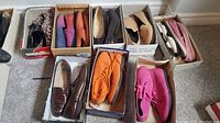 10 pairs of women's shoes in boxes including suede and leather flats, boots, and loafers in various colors and prints