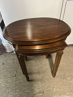 Photo of larger solid wood oval nesting table from the top showing polished wood finish and oval shape.