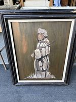 Frontal view of the signed nomad figure painting on copper panel inside a worn black wooden frame.