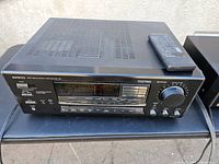 Front view of the Onkyo TX-SV515PRO tuner amplifier with control buttons, digital display, and remote on top.