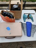 Overview of lot showing router, clamp, beige storage box, and wrench set in blue holder