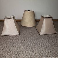 Photo of three small beige lampshades on carpet - two square with 9" bottom and one round with 11" diameter bottom.