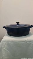 Side view of 6 quart Masterchef Dutch oven showing navy blue enamel and lid with black knob.