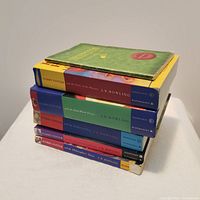 Stack of six Harry Potter paperback books showing the spines and top covers of the books, worn condition with visible corner damage on one book