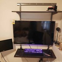 Full view of taupe powder-coated metal shelving unit with two shelves mounted on vertical rails with metal brackets. Shown with computer peripherals to illustrate usage but not included.