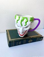 Front angled view of the 3D Joker mug showing detailed facial features, green hair, red mouth, and purple handle.