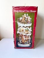 Original box featuring image of the tall three-floor Gingerbread Tree House Christmas lamp, red box with some wear and tear visible.