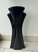 Front view of one black Art Deco floor vase showing unique flared multi-panel design and glossy finish.