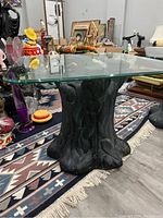 Front and side view of the vintage tree stump side stool with clear square glass top, showing carved dark wood base and glass surface.