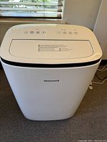 Front view of the white Honeywell portable air conditioner with visible control panel on top.