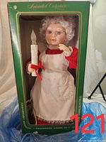 Photo of the Mrs. Claus animated collectible figure in original packaging showing details of the figure's face, clothing and candle held in hand.