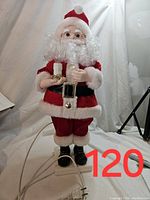 Full front view of the approximately 20" tall animated Santa Claus decoration in red velvet suit with white fur trim and black boots, holding a candle holder with light bulb.