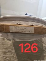 Close-up of the label on the fabric bolt showing details: '30-8360-WHTE', '150CM STRETCH GAB.', '100% POLYESTER', and '16 meters' handwritten.