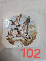 Front view of square Royal Adderley china teabag rest featuring flying ducks over marshland.