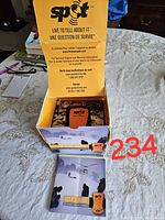 SPOT emergency beacon personal tracker device inside original branded yellow and black box with user's guide below.