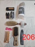 Overview of men's grooming items including brushes, combs, deo stick, lotion, and spray bottles on white background.