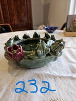 Side view showing the frogs sitting on the rim and the rosebud detail on the side