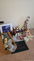 Full view of assortment of Christmas decorations with boxed items and mats on floor