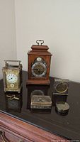 Overall lot view: three clocks and two boxes arranged on table