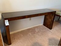 Front view of full console table showcasing dark brown veneer and black top