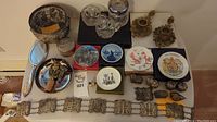 Overview of all decorative items including metal ornaments, glassware, porcelain boxes and belt
