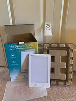 Verilux HappyLight Touch lamp displayed with original box, molded protective insert, and plastic bag.