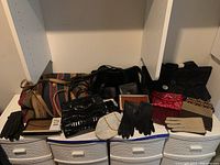 Full overview of all purses, gloves, including various textures and styles, arranged on white shelves.