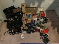 Full lot overview showing purses, scarves, belts, shoe stretchers in box, wallets and key chains spread on floor.