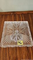 Top view of square lead crystal cake plate showing decorative cut pattern on surface and faceted edges.
