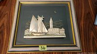 Full view of framed 3D sterling silver raised relief sculpture of a sailing ship in a cityscape setting