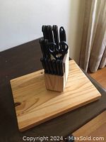 14 piece cutting tool set in wooden block on wooden surface